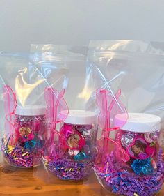 three plastic bags filled with purple and pink confetti