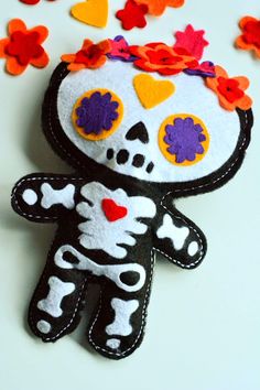 a stuffed animal with flowers on it's head and hearts around its neck in the shape of a skeleton