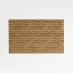 a brown door mat with wavy lines on the front and back side, against a white background