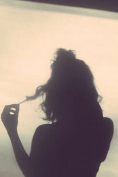 the silhouette of a woman brushing her hair