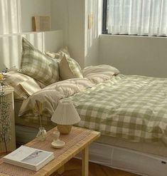 a bed sitting in a bedroom next to a table with a lamp on top of it