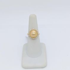 Beautiful big round golden pearl with 0.70 ct. good quality white diamond rounds.  Handmade in 18k yellow gold.  Ring size 6.25.  Metal: Yellow Gold Stone: White Diamond,Pearl Stone Cut: Round Cut  Dimensions reference the ring size and are not specific to the ring itself. Exact ring dimensions are not provided. Please reach in the seller Q&A for questions. Yellow Gold Akoya Pearl Ring, Gold Diamond Ring With Akoya Pearl, Fine Jewelry Gold Diamond Ring With Akoya Pearl, Gold Akoya Pearl Diamond Ring, Yellow Gold Diamond Pearl Ring With Halo Setting, Yellow Gold Pearl Diamond Ring With Accents, Formal Gold Pearl Ring With Halo Setting, Gold Akoya Pearl Ring, Gold Diamond Pearl Ring With Pearl Drop