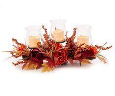 candles are placed in glass vases with autumn leaves and flowers on the bottom one