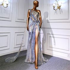 5-7 weeks processing and shipping time This design is from our Luxe x Bougie Glitter collection. This extravagant blue and gold one shoulder gown is fit for a princess! Handed beaded with sequins and featuring dramatic draping, a high front slit and an embellished train. Color may vary due to lighting Swarovski Dress, Crystal Gown, Luxury Gowns, Gold Sequin Gown, Million Dollar Baby, Celebrity Style Dresses, Crystal Wedding Dress, Celebrity Gowns, Crystal Dress