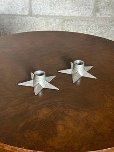 two metal stars sitting on top of a wooden table