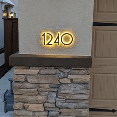 a house number sign on the side of a building with a lit up address plaque