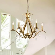 a chandelier hanging from the ceiling in a room with white walls and windows