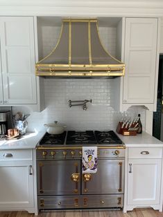 a stove top oven sitting inside of a kitchen next to white cabinets and counter tops