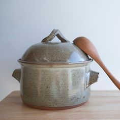 a pot with a wooden spoon sitting on top of it