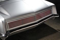 the front end of an old car with chrome paint and red stripeing on it