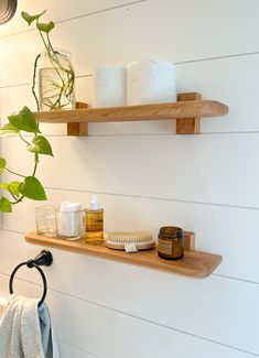 two wooden shelves holding toiletries and soaps in a bathroom with white shiping