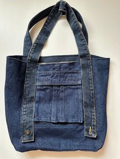 a denim bag hanging on the wall with an open pocket in it's front