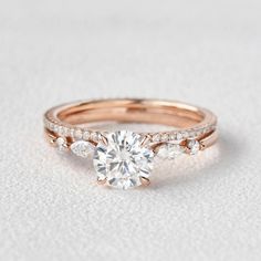 a rose gold engagement ring with diamonds on the band and a round diamond in the center