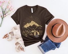 Prepare to embark on a journey of a lifetime with our 'Adventure Awaits' shirt! This shirt is not just a piece of clothing, it's a symbol of endless possibilities and exciting experiences waiting to be discovered. Made with high-quality fabric and featuring a bold and inspiring design, this shirt is perfect for explorers, dreamers, and anyone with a passion for the great outdoors. Whether you're climbing mountains, camping under the stars, or simply seeking new adventures, let this shirt be your Summer Adventure Short Sleeve Shirt, Summer Shirt With Screen Print For Outdoor Activities, Summer Outdoor Shirt With Screen Print, Summer Travel Tops With Graphic Print, Summer Travel Graphic Tee Tops, Pre-shrunk Relaxed Fit Adventure Shirt, Pre-shrunk Relaxed Fit Shirt For Adventure, Summer Camping Tops With Screen Print, Pre-shrunk Summer Adventure Shirt