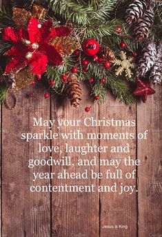 a christmas card with pine cones, holly and red berries on wooden planked surface