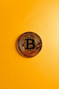 a bit coin sitting on top of a yellow surface