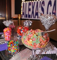 a table topped with lots of candy and candies on top of glass bowls filled with confetti