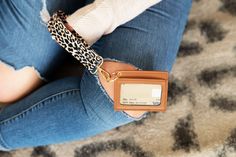 a woman sitting on the floor with her purse and credit card holder in her hand