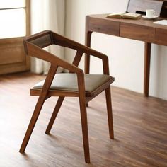 a wooden chair sitting on top of a hard wood floor next to a desk with a laptop computer