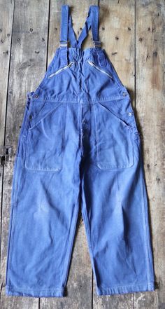 "A pair of French cotton twill overalls by classic workwear brand Adolphe Lafont, dating from the late 1940s or early 1950s. Noted flaws - uneven faded colour throughout, frayed damage at the pocket and fly seams, loss of elasticity to the shoulder straps, wear at the knees and ankle cuff edges, various spot marks throughout - please see photos. Freshly laundered, thick cotton, adjustable waist and shoulder straps, button fly, hammer loop at the back, great label, all pocket zippers run smoothly, classic French workwear, suitable for everyone. Measurements taken lying flat -  Waist - 18\" - 19\" (36\" - 38\" doubled) Rise - 12.5\" Hips - 23\" (46\" doubled) Bib top - waist - 10.5\" Inside leg - 24\" Leg opening at hem - 10.5\" Please check your measurements carefully!" Classic Workwear, Workwear Brands, French Workwear, Ankle Cuffs, Dungarees, Cotton Twill, Shoulder Straps, Work Wear, Overalls