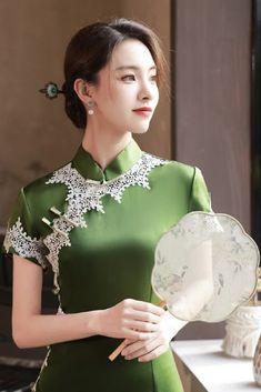 This chic long green cheongsam dress is the latest addition to the modern collection. It perfectly combines classic elements like the high mandarin collar, lace details, and knotted Chinese buttons with a contemporary design. Green Short Sleeve Dress For Wedding, Green Elegant Cheongsam With Stand Collar, Elegant Green Cheongsam With Stand Collar, Green Short Sleeve Maxi Dress For Formal Occasions, Green Stand Collar Cheongsam For Spring, Spring Green Cheongsam With Stand Collar, Elegant Green Dress With Stand Collar, Elegant Light Green Fitted Maxi Dress, Elegant Light Green Dress With Short Sleeves