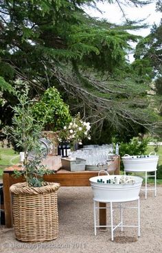 an outdoor bar set up in the middle of a yard with wine glasses and bottles on it