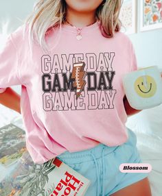 Game Day FOOTBALL T Shirt  *PRINTING COLORS* White Printing - On Pepper/ Black/ Red/ Light Green/ Mystic Blue/ Espresso ✍️Our graphic T-Shirts are designed to make a statement and elevate your wardrobe with unique, eye-catching designs. Each shirt is crafted from high-quality US cotton, ensuring all-day comfort and durability. Whether you're looking for a casual outfit or something to express your personality, our graphic tees are perfect for any occasion. 👕👚SIZING: Unisex Adult  S, M, L, XL, 2XL, 3XL 🦊HOW TO ORDER 1️⃣Select your preferred size and color 2️⃣*If there is Customization option available, follow the direction to enter your custom text   3️⃣Add to cart 4️⃣If you need more Items to your order please press the back button and repeat steps. Once all your desired items are in yo Cheap Game Day T-shirt With Name Print, Outfit School, Game Day Football, Game Day Outfit, Football Gift, Shirt Football, Football T Shirt, School Team, Game Day Shirts