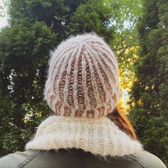 the back of a woman's head wearing a white and brown knitted hat