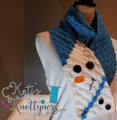 a knitted snowman scarf on top of a mannequin