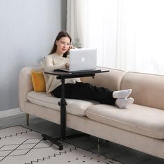 a woman sitting on a couch using a laptop computer