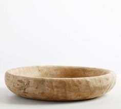 a wooden bowl sitting on top of a white table