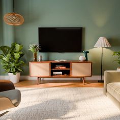 a flat screen tv sitting on top of a wooden entertainment center in a living room