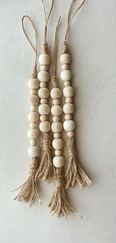 three wooden beads with tassels hanging from strings