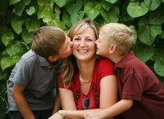 a woman and two boys kissing on the cheek