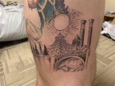 a man with a tattoo on his leg that has an image of a factory in the background