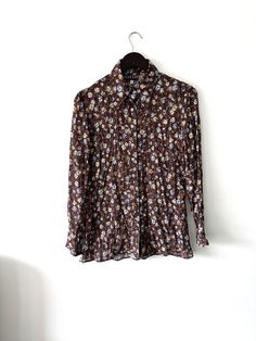 It's a Vintage 90s brown floral cute romantic shirt, blouse. Butterfly collar. Long sleeves. Button up closure. Lightweight. 150gr. Brand: MORGAN. Size: L - M. Material: Polyester. Great vintage condition. Model's height: 5'8 / 178 cm / Size S. MEASUREMENTS: Shoulders: 16 inch / 42 cm. Sleeve:  23 inch / 60 cm. Bust doubled: 42 inch / 106 cm. Length: 30 inch / 77 cm. Worldwide shipping. Shipping takes to: USA 7-14 days.  EU 4-7 days. Others countries 7-14 days. Brown Vintage Print Top For Spring, Brown Button-up Blouse With Buttons, Brown Long Sleeve Floral Print Tops, Brown Floral Print Long Sleeve Tops, Brown Buttoned Shirt For Spring, Brown Shirt With Buttons For Spring, Brown Shirt With Buttons, Vintage Brown Floral Print Tops, Brown Floral Print Shirt For Spring