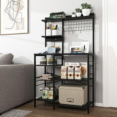 a living room filled with furniture and a book shelf next to a gray couch on top of a hard wood floor