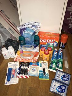 an assortment of personal care products on a wooden floor next to a door and wall