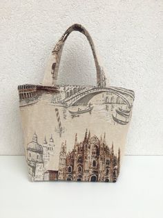 Shoulder bag handmade in Sicily Bucket model with print of the main Italian monuments Milan Cathedral, Bridge with gondola in Venice, Colosseum in Rome. Made of fine GOBELIN fabric that recalls the famous GOBELINS tapestries Internally it is lined and on which I have applied a large pocket Measures: Height 26cm Width 24cm Depth 14cm Handle height 18 cm Unique piece / One of a Kind bag You can find my other articles on https://www.etsy.com/it/shop/GirosSICILIA Beige Fabric Bag For Daily Use, Beige Fabric Bags For Daily Use, Beige Tote Bag With Zipper Pouch, Fabric Bags With Zipper Pouch As Gift, Handmade Pouch Canvas Bag For Daily Use, Handmade Beige Canvas Bag For Daily Use, Fabric Travel Pouch Bag, Handmade Canvas Pouch Bag For Daily Use, Fabric Shoulder Bag Suitable For Gifts