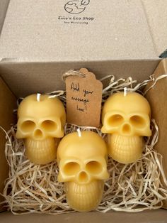 three yellow skulls are in a cardboard box