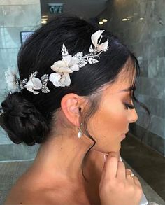 a woman wearing a white flower hair comb