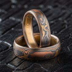 "* Price may vary depending on ring size, please inquire with us directly with your needed size for accurate pricing! This gorgeous Mokume Gane ring set features our Woodgrain pattern, varied finishes, and a Low Dome profile. This set is made with our \"Firestorm\" metal combination that contains 14k Red gold, 14k Yellow Gold, Palladium, and Sterling Silver. The highlight colors in this set feature palladium. Highlights vary with mokume and cant be guaranteed in this pallet.  Mokume Gane Band Set - Ring 1 Width Shown: 5mm Size Shown: 7 Pattern: Woodgrain  Palette: Firestorm  Finish: Etched & Oxidized Profile: Low Dome  Mokume Gane Band Set - Ring 2 Width Shown: 6mm Size Shown: 9.25 Pattern: Woodgrain  Palette: Firestorm Finish: Etched & Oxidized Profile: Low Dome  Price does NOT include st Unique Engraved Ring For Wedding, Unique Engraved Etched Wedding Ring, Unique Engraved Wedding Ring With Etched Design, Artisan Etched Jewelry For Wedding, Modern Engraved Jewelry For Wedding, Artisan Engraved Rings For Formal Occasions, Artisan Engraved Ring For Wedding, Unique Etched Jewelry For Wedding, Unique Etched Wedding Jewelry