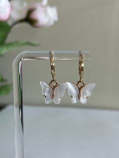 18K Gold-Plated Butterfly Hoop Earrings | White Butterfly Earrings These butterfly earrings come in a variety of beautiful colors including pink, white, red and purple. These earrings are comfortable and affordable, made with 18K gold-plated huggie hoops. Their simple yet elegant feel make them easy to pair with any outfit.  Details: Lightweight Hypoallergenic Nickel-free Measurements ο Drop Length: 2.0cm. ο Width: 1.0cm. Gifting ο Leave a message and I can add a personal note to the package. :) Trendy White Drop Clip-on Earrings, Gift Huggie Clip-on Earrings, Huggie Clip-on Earrings For Gifts, Trendy White Round Hoop Earrings, White Single Dangle Clip-on Earring, Trendy White Pierced Earrings, White Elegant Huggie Earrings, White Hypoallergenic Drop Clip-on Earrings, White Hypoallergenic Huggie Jewelry