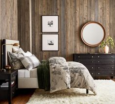 a bedroom with wood paneling and white furnishing on the floor, bedding is made up