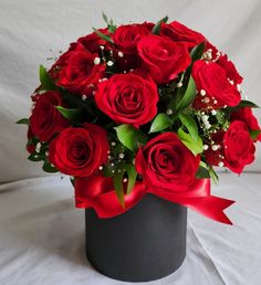 a bouquet of red roses in a black vase