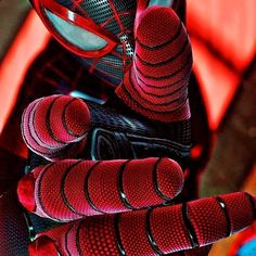 a pair of red and black gloves hanging from the side of a bike helmet on top of it