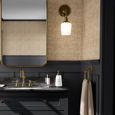 a bathroom vanity with two sinks and a large mirror above it, along with a gold faucet