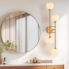 a bathroom vanity with a round mirror and lights on the wall next to it,