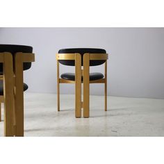 two wooden chairs and one black leather chair