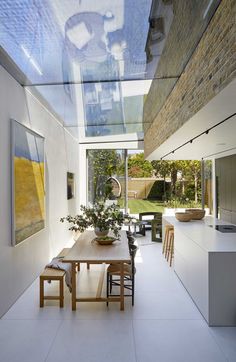 a dining room with a table and chairs in front of a glass roofed area